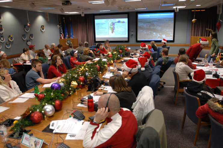 Men and women sitting around a long table that's been decorated for Christmas